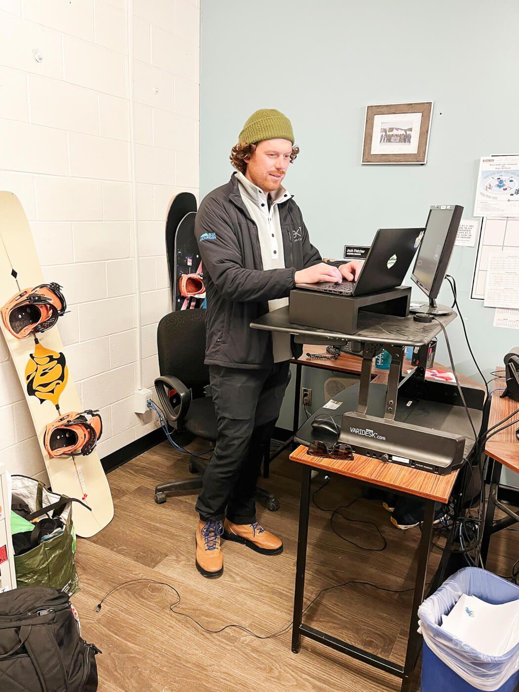 A person working on a computer at a standing desk